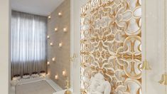 a white bathroom with gold accents and candles on the wall, along with a teddy bear