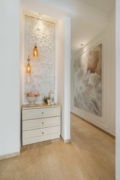 a bathroom with white walls and wood flooring next to a painting on the wall