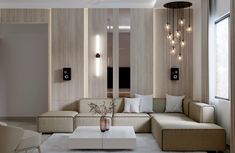 a living room with couches, tables and lamps on the wall in it's center