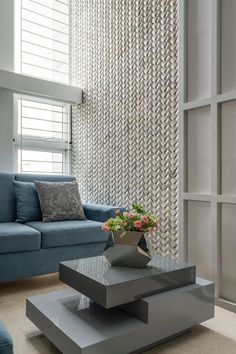 a living room with blue couches and a coffee table in front of a window